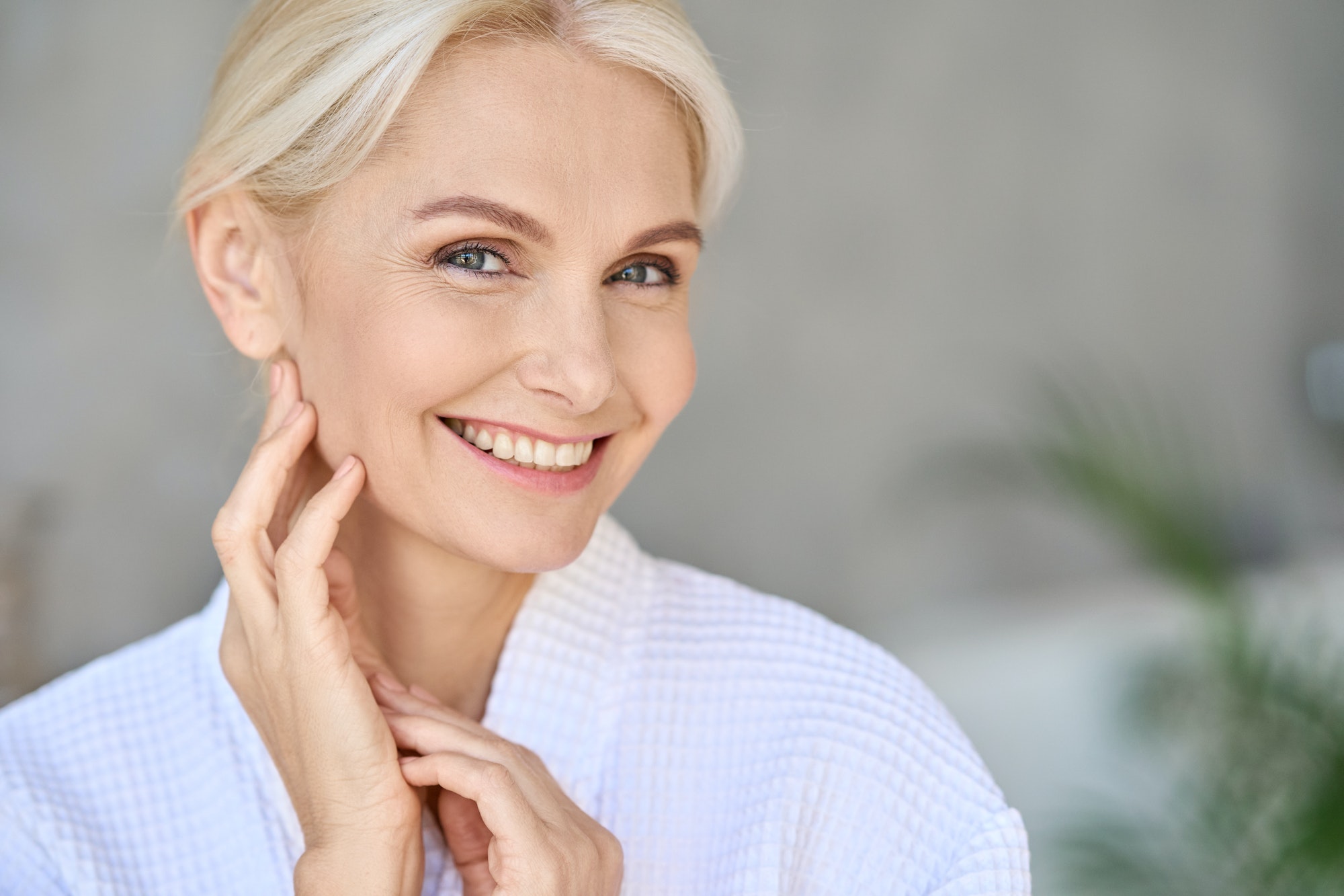 Portrait of smiling mid age woman looking at camera. Skin care concept.