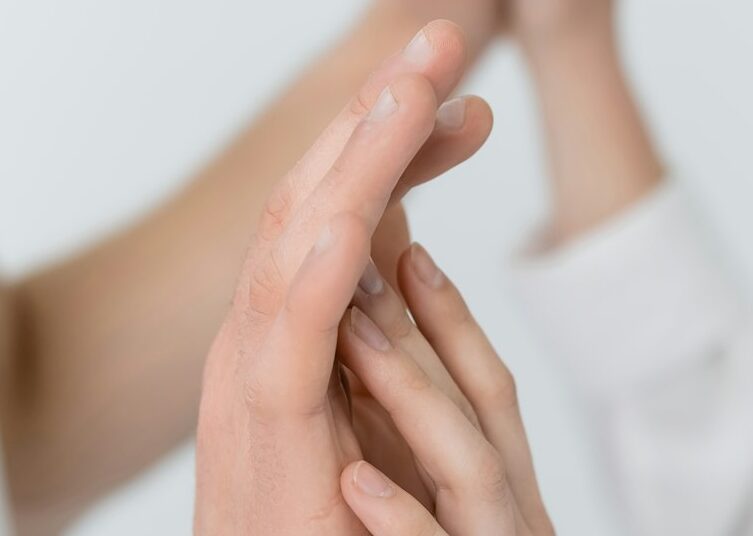 Cropped view of blurred couple touching hands isolated on white