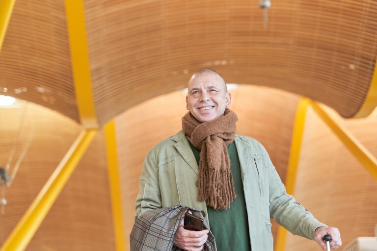 portrait of smiling 50-year-old man with suitcase in hand