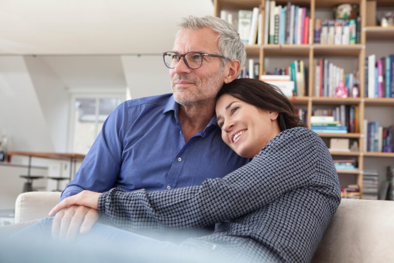 Smiling mature couple cuddling at home